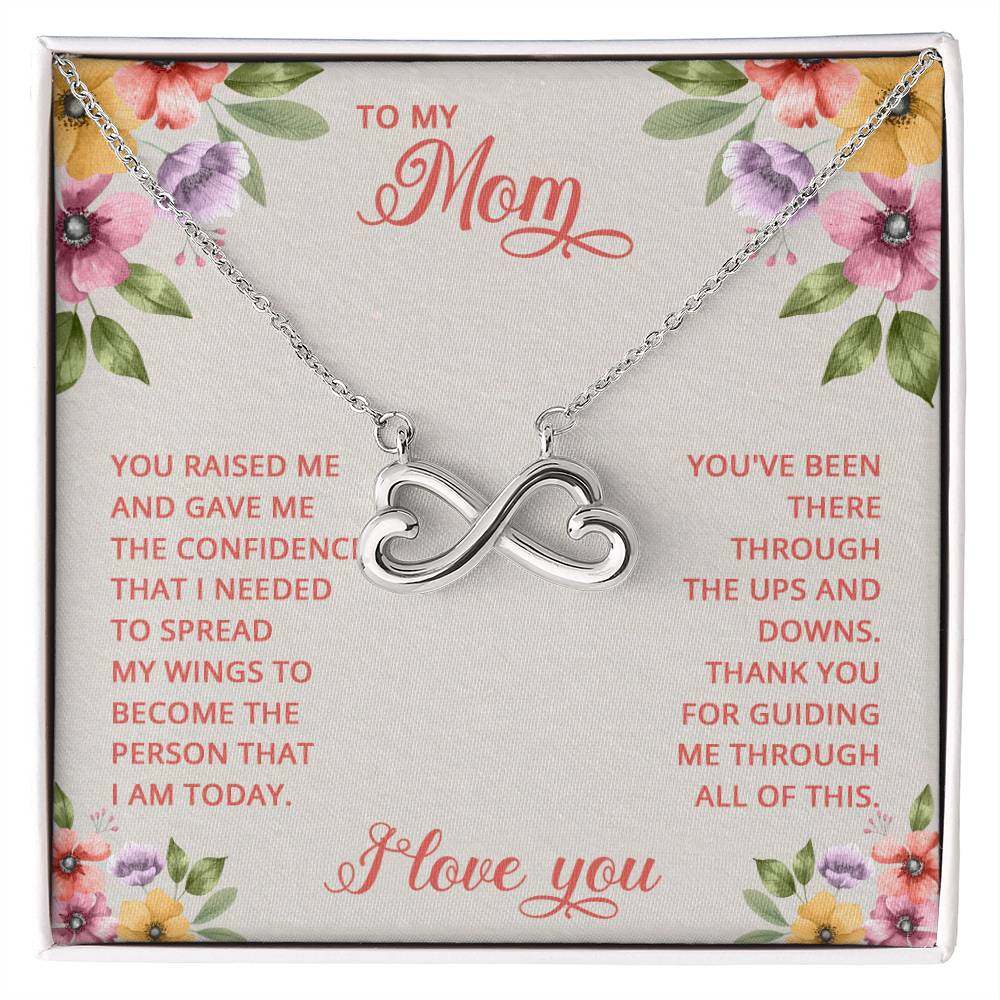 Endless Love Necklace for Mom with heart-shaped infinity symbol in white gold finish, displayed on floral background.